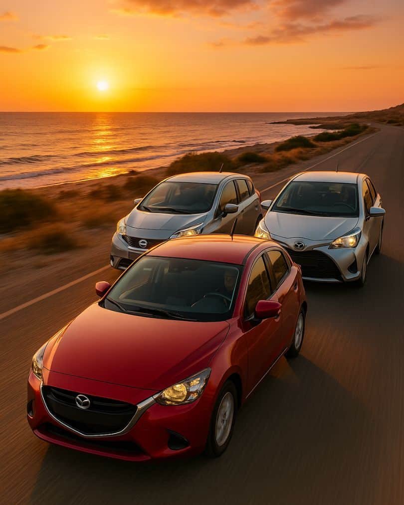 „Három autó egymás mellett az úton, tengerrel és naplementével a háttérben”